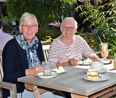 Zwei Damen lassen sich Stachelbeertorte beim Hofcafé Liesel und Lotte auf Hof Gösling in Osnabrück-Pye schmecken.