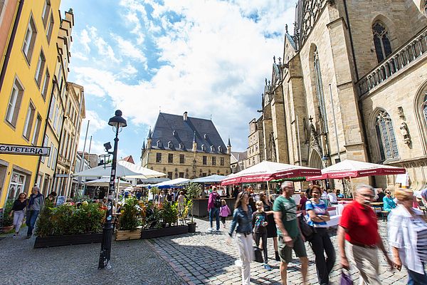 Das Rathaus des Westfälischen Friedens, Stadtwaage und Marienkirche auf der einen, typische Osnabrücker Bürgerhäuser mit ihren Treppengiebeln auf der anderen Seite umranden den historischen Platz.