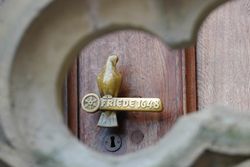 Türklinke am historischen Rathaus von Osnabrück. Eine goldene Taube sitzt auf einer Symbolstange.
